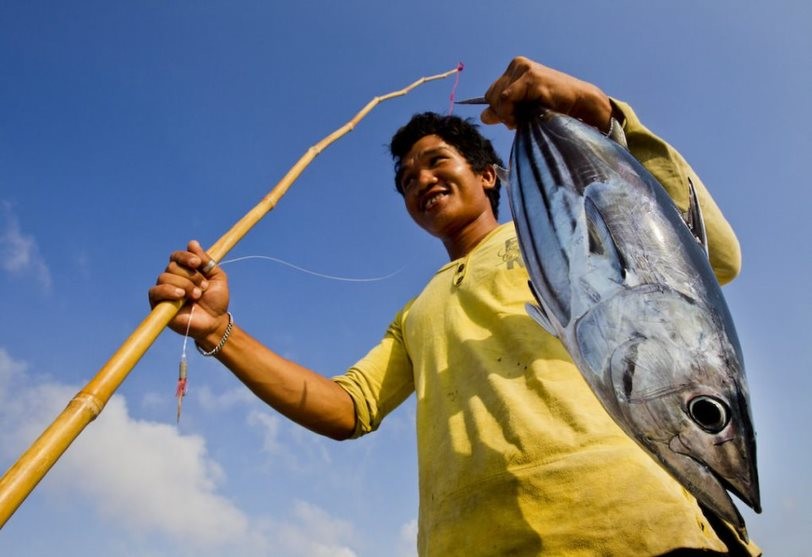 Pescatore indonesiano con tonnetto striato